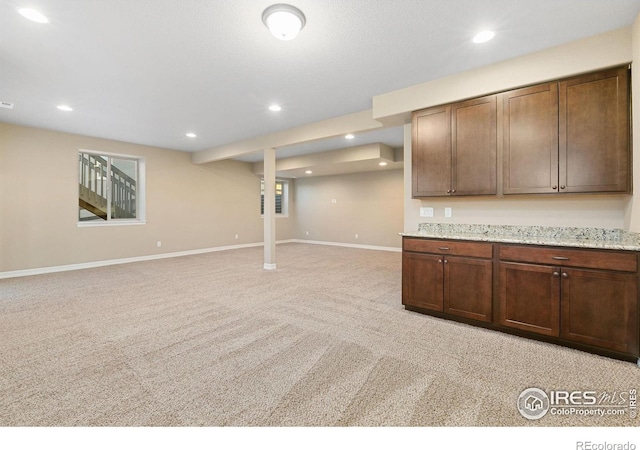 below grade area with light carpet, recessed lighting, and baseboards