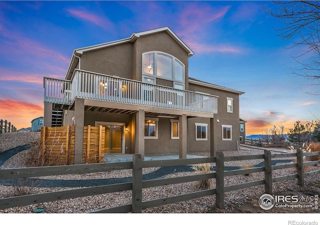 rear view of property featuring fence private yard, a deck, and stucco siding