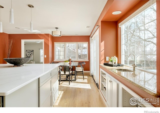 1516 Columbine Ave, Boulder, CO 80302 - kitchen featuring white cabinets, baseboards, a sink, and light wood-style floors
