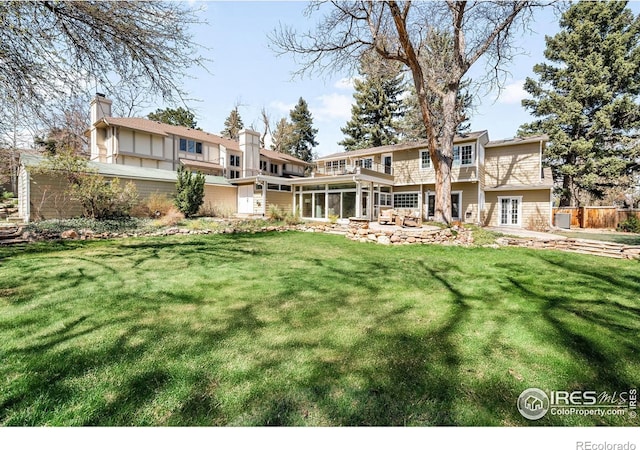1516 Columbine Ave, Boulder, CO 80302 - rear view of property with a lawn, fence, a chimney, and a sunroom