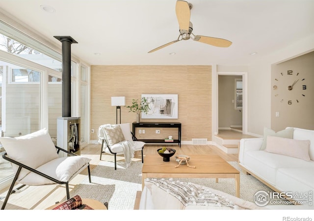 1516 Columbine Ave, Boulder, CO 80302 - living area featuring wood finished floors, ceiling fan, a wood stove, baseboards, and visible vents