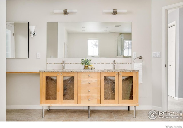 1516 Columbine Ave, Boulder, CO 80302 - bathroom with baseboards, a sink, backsplash, and double vanity
