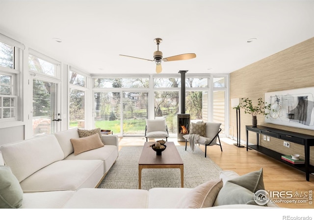 1516 Columbine Ave, Boulder, CO 80302 - living area featuring ceiling fan, expansive windows, a wood stove, and light wood finished floors