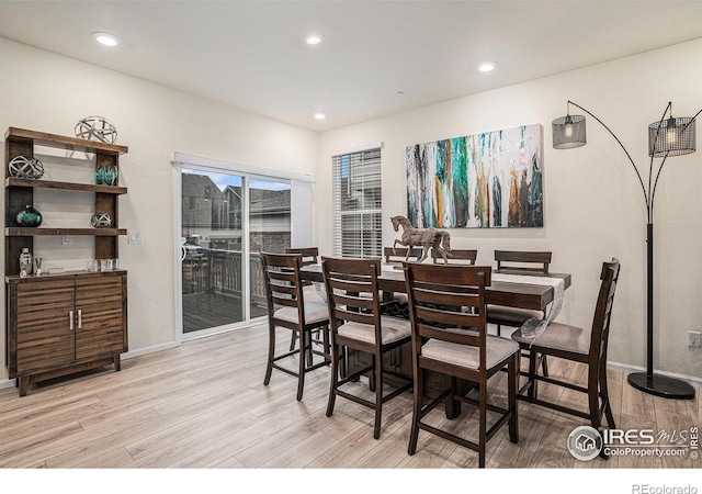 dining room with baseboards, light wood-style flooring, and recessed lighting