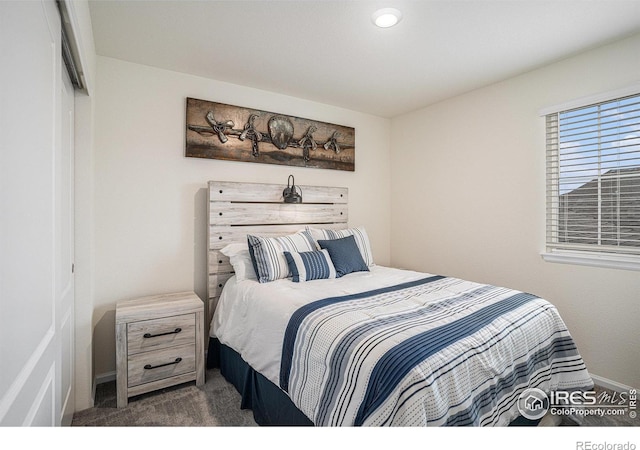 bedroom with dark carpet and a closet