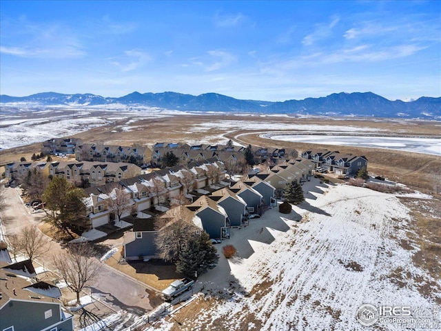 snowy aerial view with a residential view and a mountain view