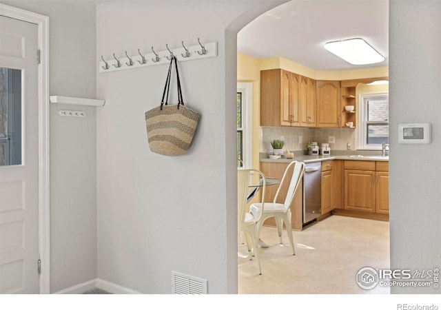 kitchen with open shelves, light countertops, visible vents, decorative backsplash, and stainless steel dishwasher