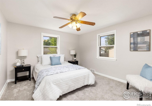 bedroom with light carpet, baseboards, visible vents, and a ceiling fan