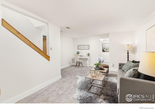 living room with carpet, visible vents, and baseboards