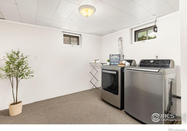 laundry area with ornamental molding, washer and dryer, laundry area, and light carpet