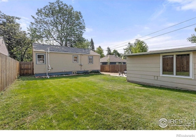 back of house featuring a patio area, a fenced backyard, and a yard