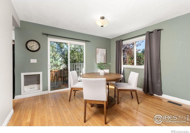 dining room with light wood finished floors, baseboards, and visible vents