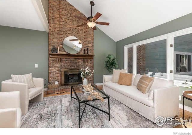 living area featuring lofted ceiling, light wood-style flooring, a brick fireplace, ceiling fan, and baseboards