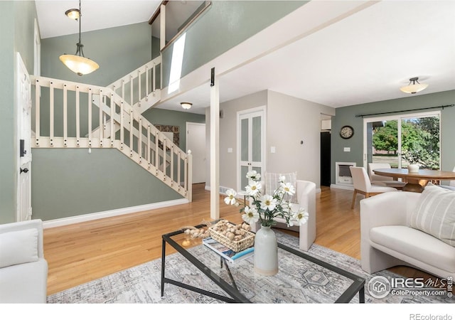 living room with stairway, wood finished floors, and baseboards