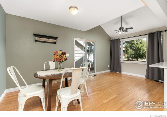 dining area with visible vents, baseboards, ceiling fan, vaulted ceiling, and light wood-style floors