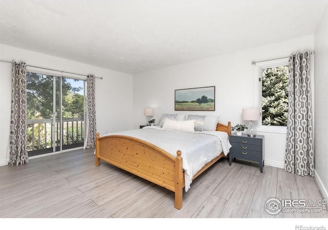 bedroom with light wood-type flooring, access to exterior, and baseboards