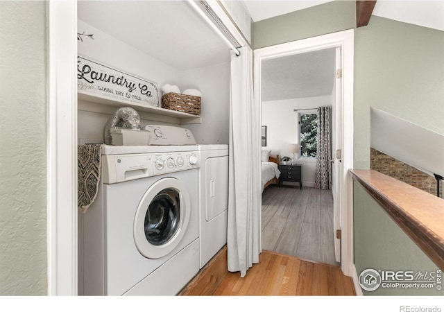 laundry room featuring laundry area, light wood-style flooring, and washer and dryer