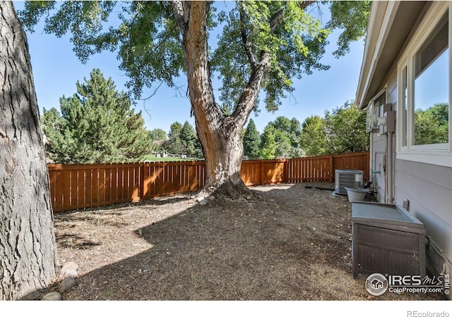 view of yard with a fenced backyard and central air condition unit