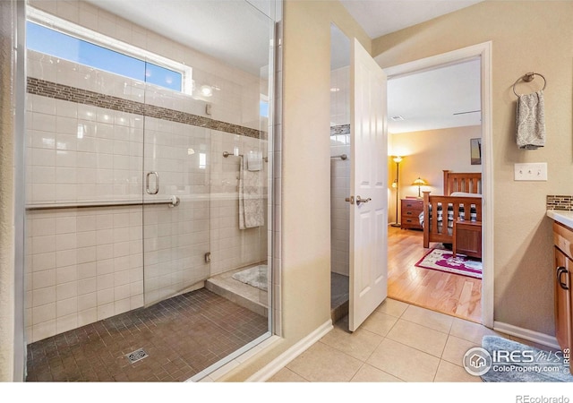 full bathroom with baseboards, tiled shower, ensuite bath, tile patterned flooring, and vanity