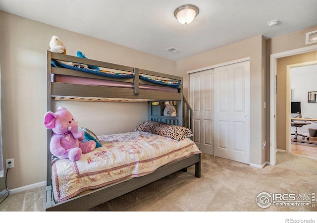 bedroom featuring light carpet, baseboards, visible vents, and a closet