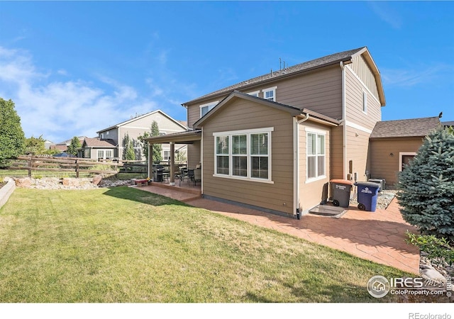 rear view of house featuring a yard, a patio, and fence