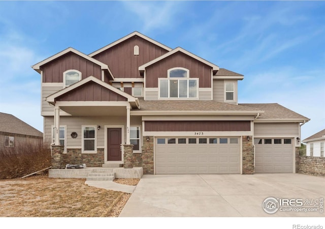 craftsman house featuring driveway, stone siding, a shingled roof, and board and batten siding