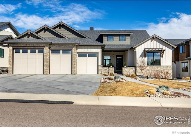 view of front of property with a garage, stone siding, and board and batten siding