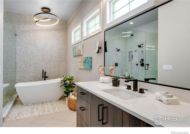 full bathroom featuring a stall shower, tile patterned floors, a freestanding bath, and vanity