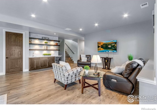 living area featuring recessed lighting, light wood finished floors, and a dry bar