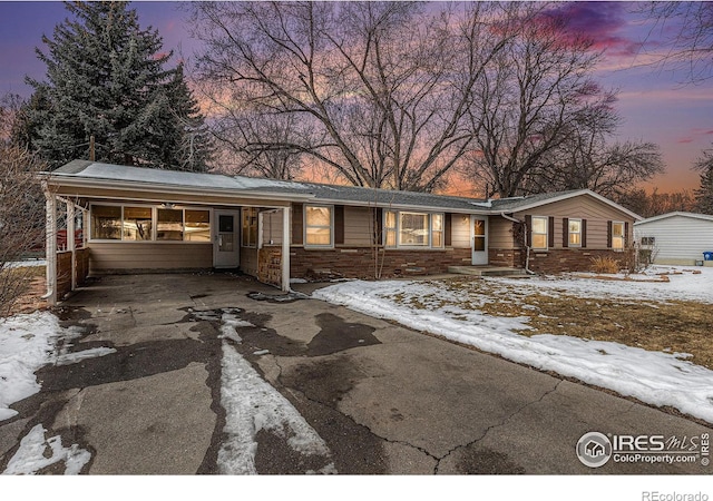 ranch-style home featuring an attached carport and driveway