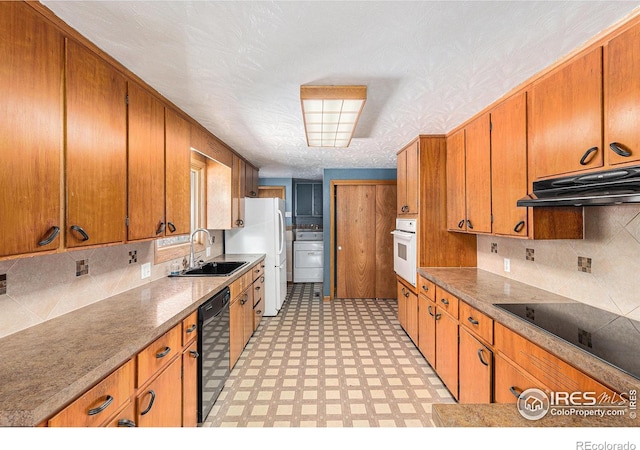 kitchen with light floors, under cabinet range hood, a sink, brown cabinets, and black appliances