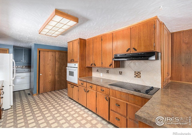 kitchen featuring light floors, light countertops, brown cabinetry, white appliances, and under cabinet range hood