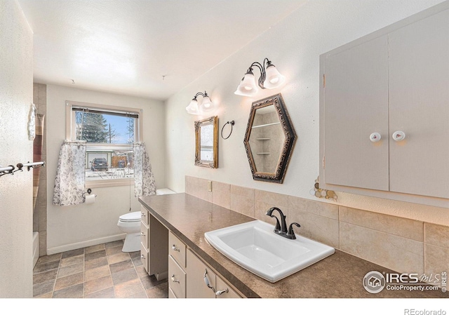 bathroom with tasteful backsplash, baseboards, vanity, and toilet