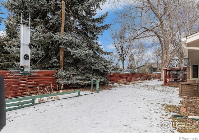 yard layered in snow featuring fence