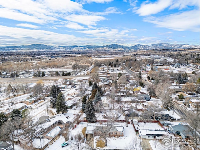 snowy aerial view featuring a residential view and a mountain view