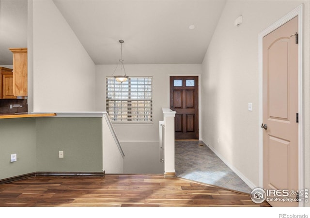 entrance foyer featuring lofted ceiling, dark wood-style flooring, and baseboards