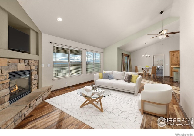 living room featuring lofted ceiling, a stone fireplace, recessed lighting, wood finished floors, and washing machine and clothes dryer