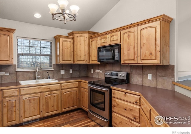 kitchen featuring lofted ceiling, dark countertops, stainless steel electric range oven, black microwave, and a sink