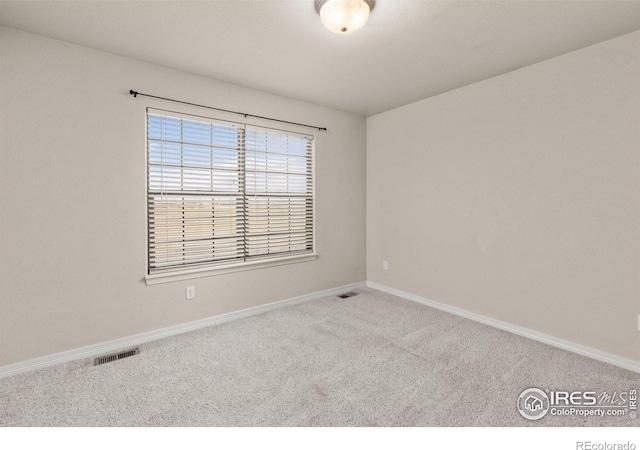 carpeted empty room featuring visible vents and baseboards