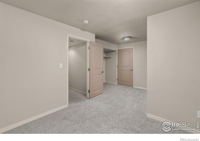 spare room with light carpet and baseboards