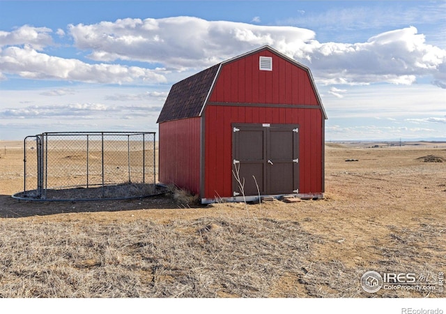 view of shed featuring fence and a rural view