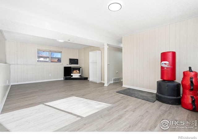 living room with baseboards, visible vents, and wood finished floors