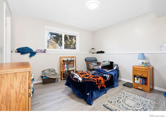 bedroom with baseboards and wood finished floors