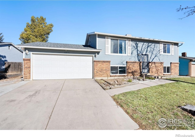 view of front of house featuring a garage, brick siding, driveway, and fence