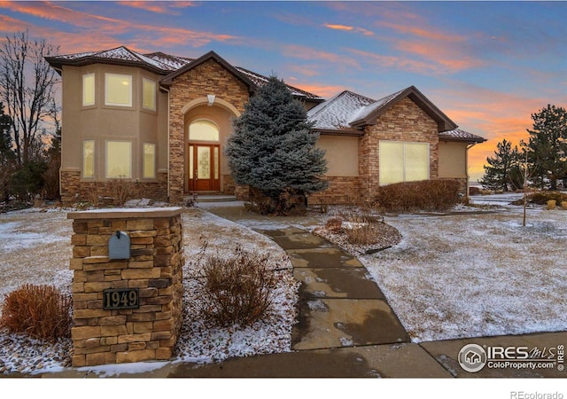 view of front of house featuring stone siding and stucco siding