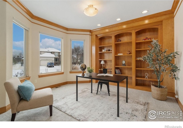 office area with built in shelves, light colored carpet, crown molding, and baseboards