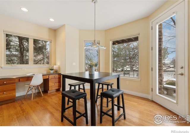 dining area with light wood-type flooring, recessed lighting, baseboards, and built in study area