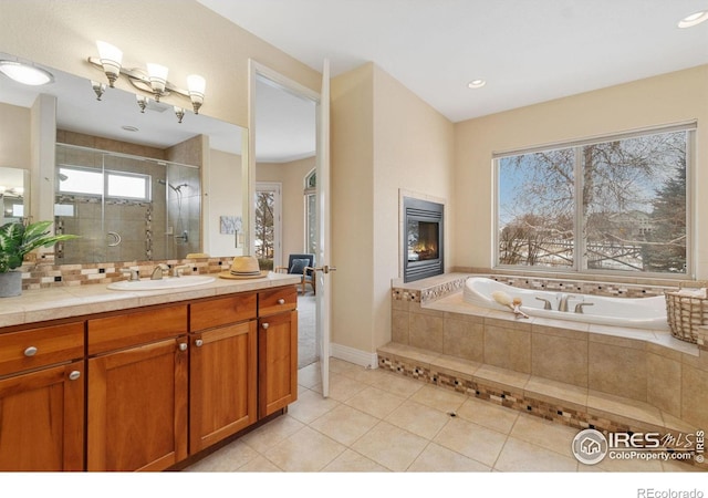 full bath featuring a fireplace, tile patterned floors, a stall shower, vanity, and a bath