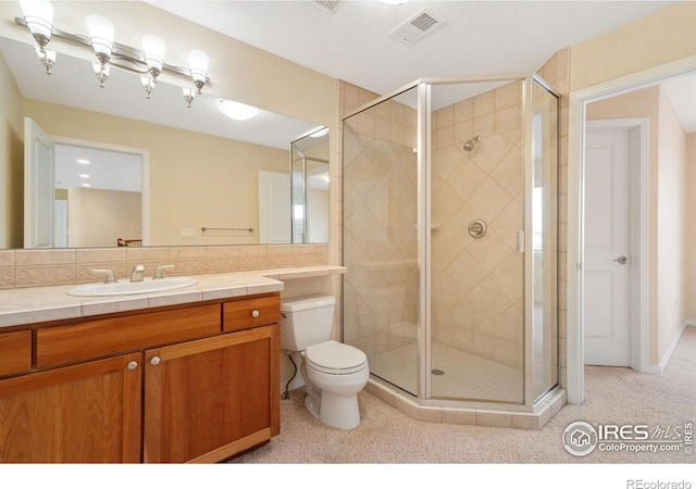 full bathroom with toilet, vanity, visible vents, and a shower stall