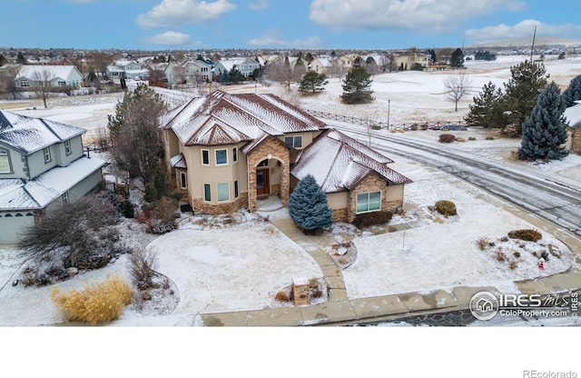 snowy aerial view with a residential view